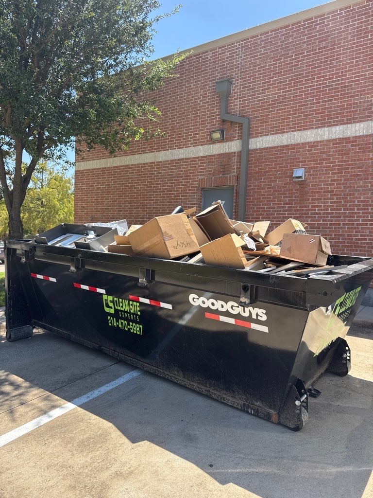 Clean Site Experts dumpster loaded with boxes at a commercial building